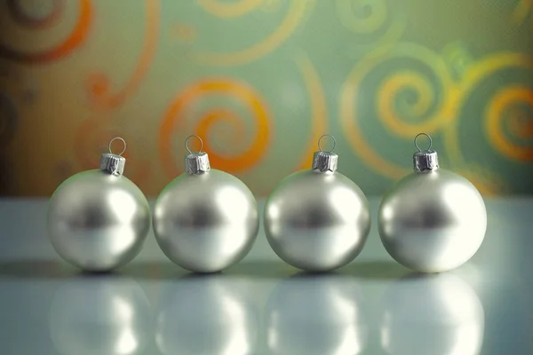 Arka plan üzerinde dört gümüş baubles — Stok fotoğraf