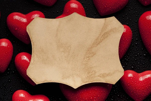 Паперовий ярлик на фоні червоних сердець — стокове фото