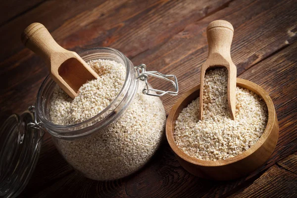 Buckwheat in a jar and wooden bowl — Stock Photo, Image