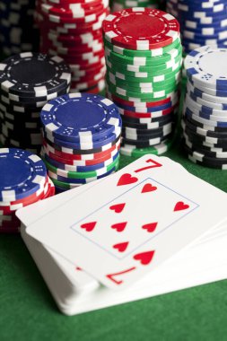 İskambil kartları ve yeşil masada poker fişleri