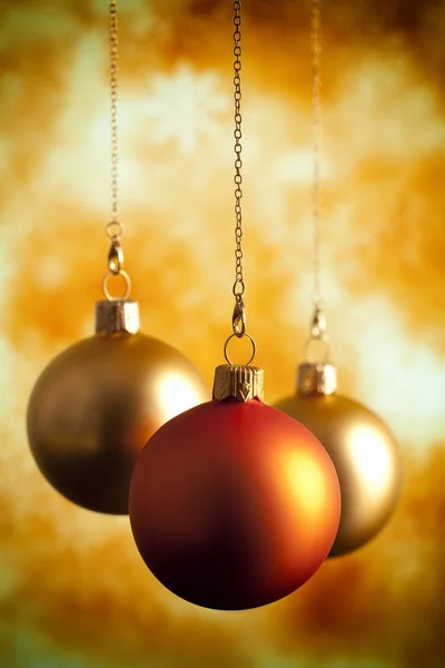 Три рождественских безделушки на абстрактном фоне — стоковое фото