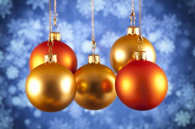 Mavi arka plan üzerinde kırmızı ve altın baubles