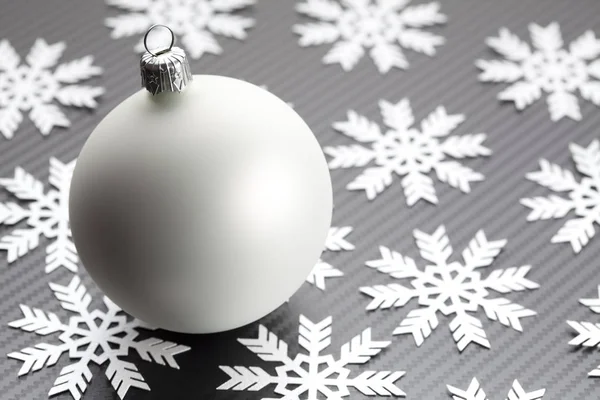 Beyaz Noel biblo ve siyah arka plan üzerine kar taneleri — Stok fotoğraf
