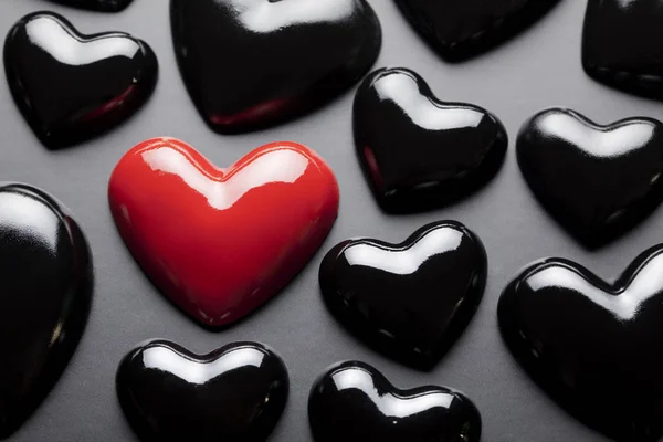 Un corazón rojo y muchos corazones negros —  Fotos de Stock