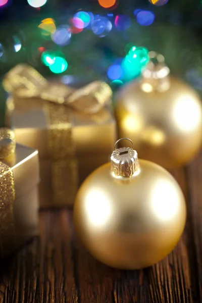 Arany karácsonyi baubles és díszdobozok, fából készült háttér — Stock Fotó