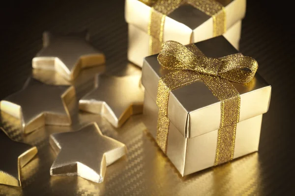 Cajas de regalo y estrellas sobre fondo dorado — Foto de Stock