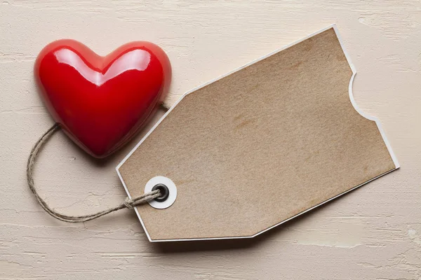Coração vermelho e tag no fundo rebocada — Fotografia de Stock