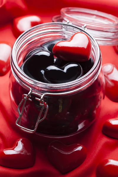 Preto e vermelho corações em fundo frasco e tecido — Fotografia de Stock