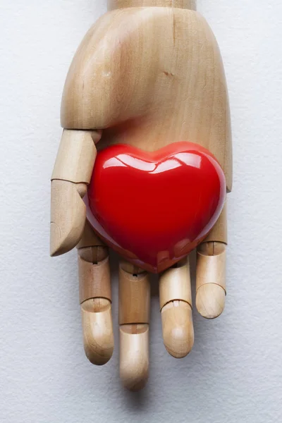 Rotes Herz in falscher Hand auf weißem Papier Hintergrund — Stockfoto