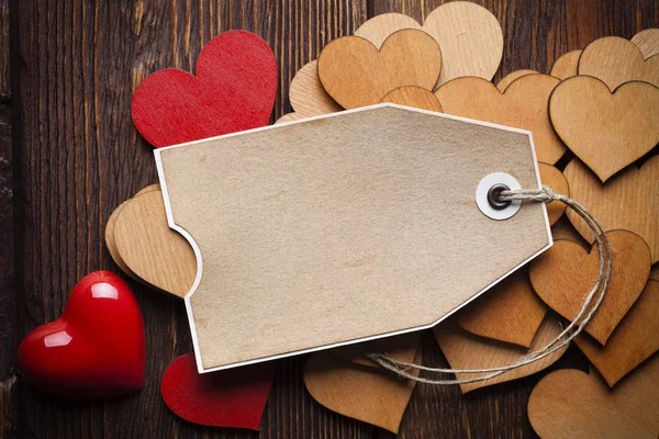 Corações vermelhos e de madeira e etiqueta de papel em branco — Fotografia de Stock