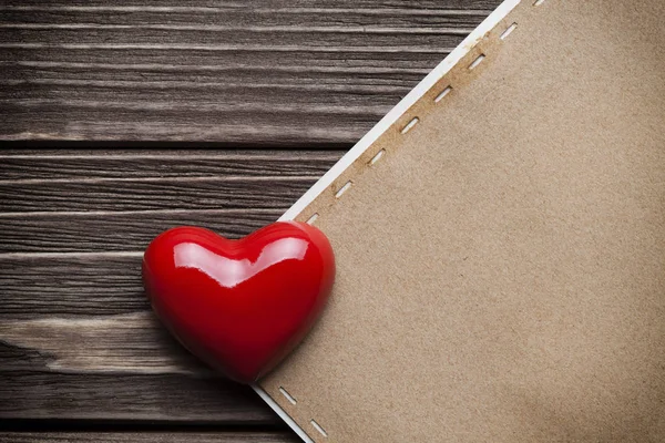 Κόκκινη καρδιά και κενό χαρτί ετικέτας στις ξύλινες σανίδες — Φωτογραφία Αρχείου