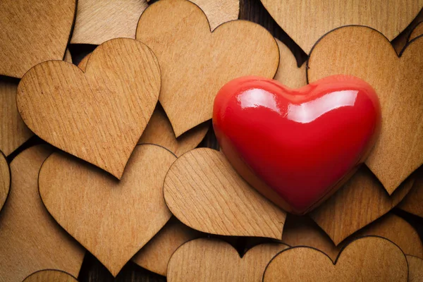 Corazón rojo sobre fondo de corazones de madera — Foto de Stock