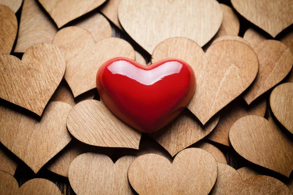 Corazón rojo sobre fondo de corazones de madera —  Fotos de Stock