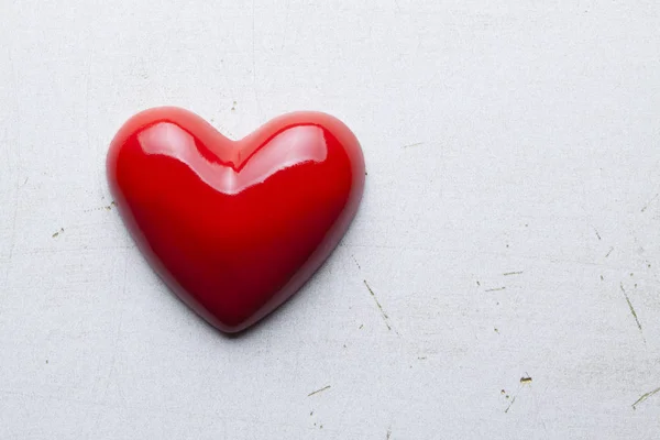 Placa de madera en blanco en mano de madera y corazones rojos en fondo — Foto de Stock