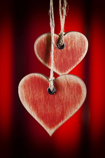 Två trä hjärtan på röd bakgrund — Stockfoto