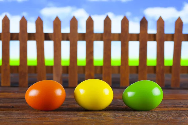 Three easter eggs on wooden table and nature background — Stock Photo, Image