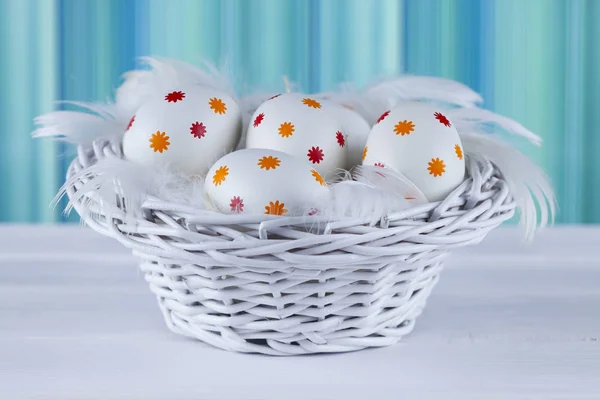 Huevos de Pascua estampados en la cesta sobre mesa de madera —  Fotos de Stock