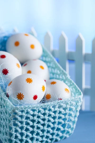 Uova di Pasqua nel cesto e recinzione bianca — Foto Stock