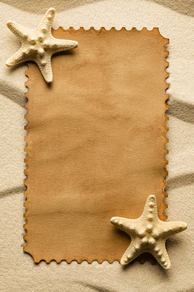 Blank paper label and starfish on beach sand — Stock Photo, Image