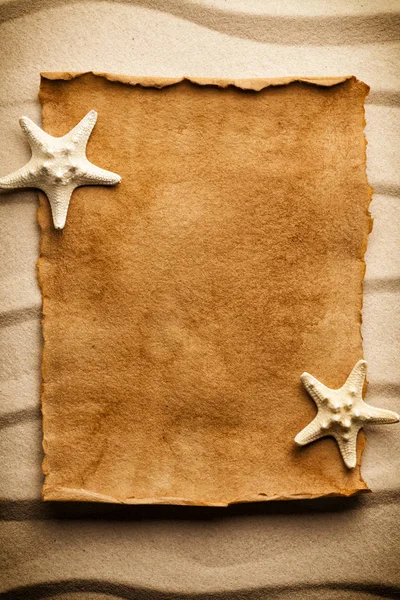 Foglio di carta bianco fatto a mano e stelle marine sulla sabbia — Foto Stock