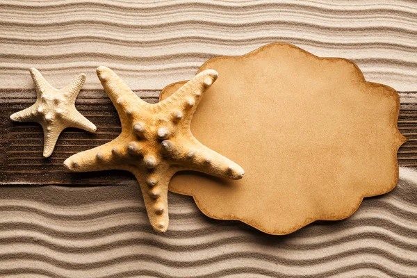Boş kağıt levha ve denizyıldızı plaj kum üzerinde — Stok fotoğraf