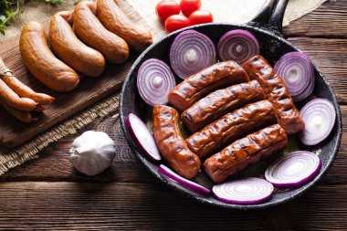 Çiğ ve pişmiş sosis, pan, otlar ve sebze 