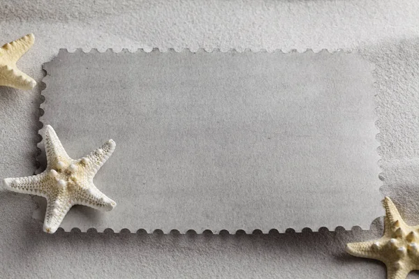 Folha de papel em branco e estrela-do-mar na areia da praia — Fotografia de Stock