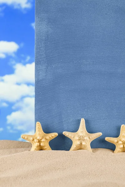 Starfishes and blue sheet on beach sand — Stock Photo, Image