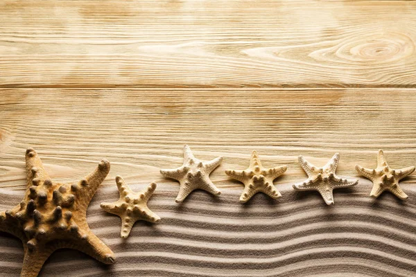 Starfishes, areia e mesa de madeira — Fotografia de Stock