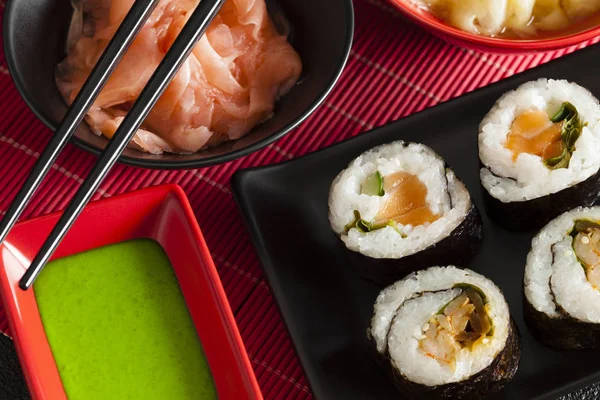 Sushi no tapete vermelho - rolos de sushi, wasabi e gengibre — Fotografia de Stock