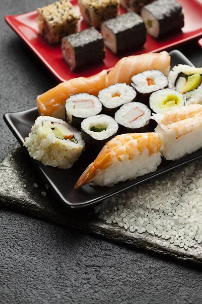 Cozinha japonesa tradicional - sushi na mesa preta — Fotografia de Stock