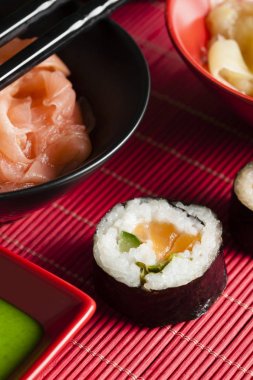 Suşi rulo, zencefil ve kırmızı mat ve siyah masa wasabi