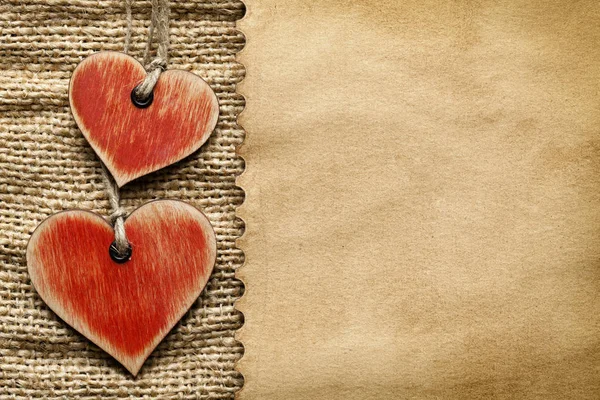 Coeurs en bois et feuille de papier sur fond de tissu — Photo