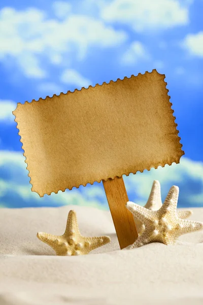 Etiqueta de papel em branco e estrelas do mar na praia — Fotografia de Stock