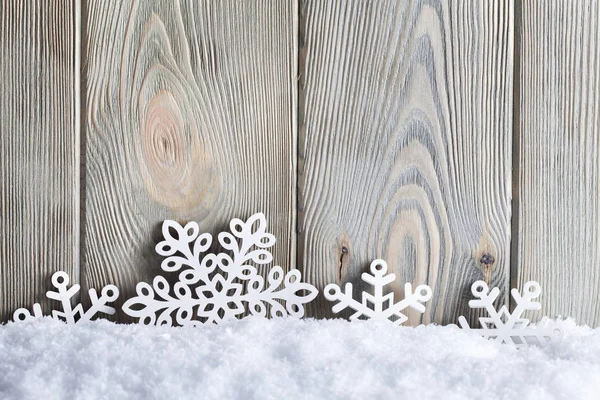 Рождественский фон - снежинки на снегу и деревянные стены — стоковое фото