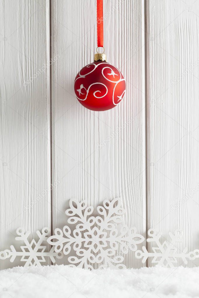 Christmas background - red bauble and snowflakes on snow and whi
