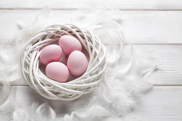 Vier Roze Paaseieren Witte Nest Veren Houten Tafel — Stockfoto