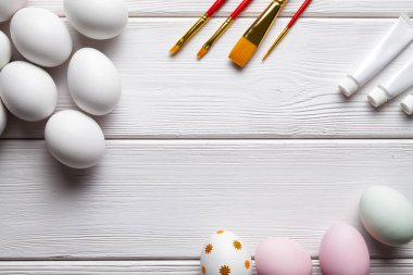 Beyaz ve boyalı Paskalya yumurta, fırçalar ve boya Beyaz ahşap tablo