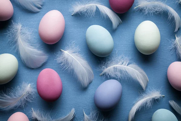 Pasen eieren en veren op blauwe achtergrond — Stockfoto