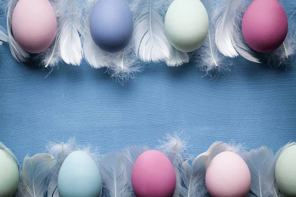 Fundo de Páscoa - Ovos coloridos e penas na mesa azul — Fotografia de Stock