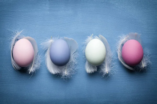 Dört Paskalya yumurtaları ve mavi renkli tüyler — Stok fotoğraf