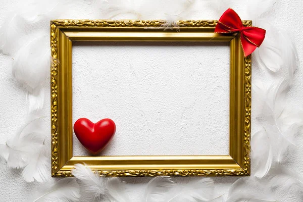Valentýn - rámeček obrázku zlaté, červené srdce a luk na bílém — Stock fotografie