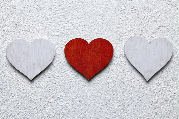 Três corações de madeira no fundo branco — Fotografia de Stock