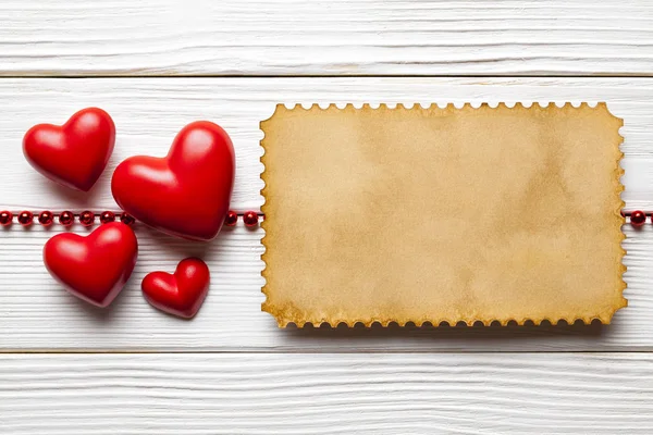 Червоні серця і чиста паперова картка на білих дошках — стокове фото