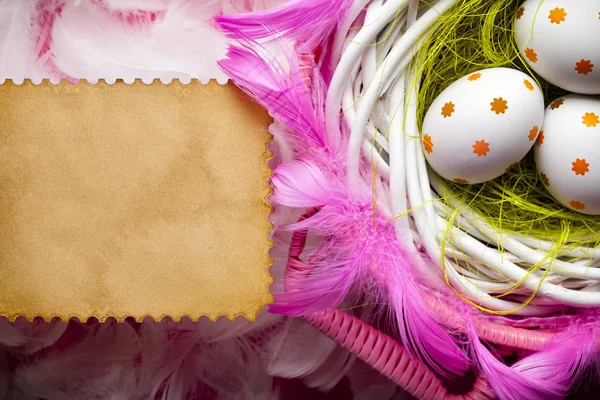 Tre uova di Pasqua dipinte nel nido, piume bianche e rosa a — Foto Stock