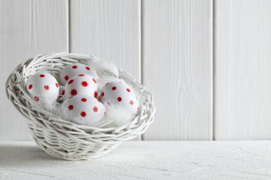 Beyaz arka plan üzerinde beyaz sepet içinde Paskalya yumurtaları