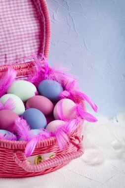 Mutlu Paskalya - pembe sepet renkli yumurta ve tüyler dolu 