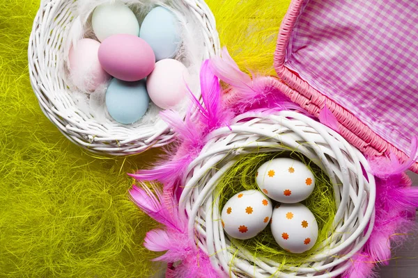 Sfondo pasquale - Uova bianche e colorate nel cestino — Foto Stock