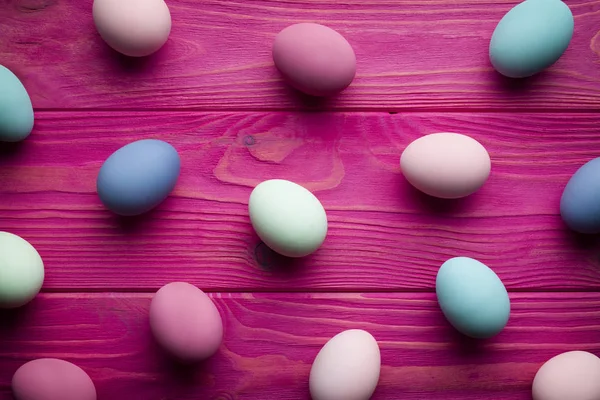 Geverfde paaseieren op roze houten planken achtergrond — Stockfoto