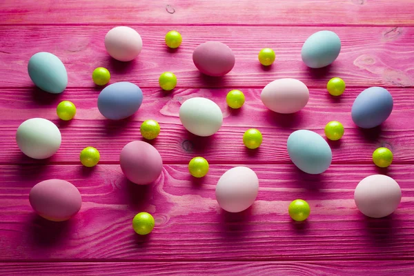 Huevos de Pascua de colores y bolas verdes sobre fondo de madera rosa —  Fotos de Stock
